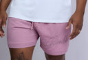 Person wearing pink shorts with 'Gambli' branding on a plain background